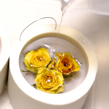 自作したシリコンモールドで黄色いミニバラの花のアメージングドライフラワーをレジンで固めている画像