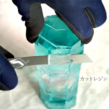 薄いピンク色のバラのアメージングドライフラワーを固めたレジンをカットしている作業の画像